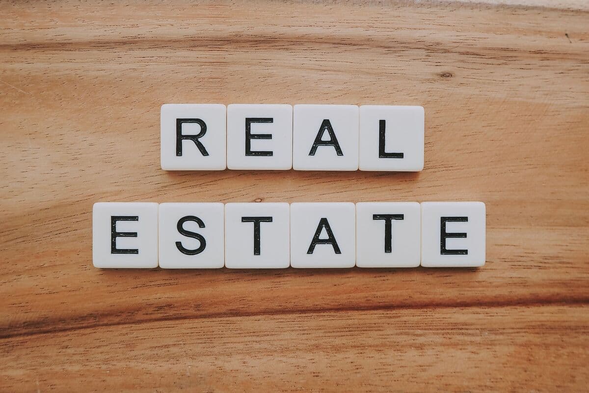Letter tiles spelling Real Estate on a wooden table